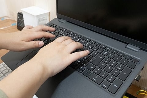 ノートパソコンを打つ人の手