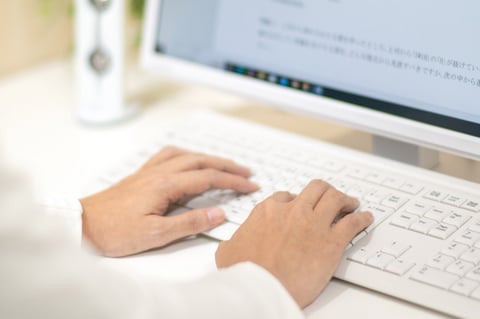 パソコンのキーボードを打つ人の手